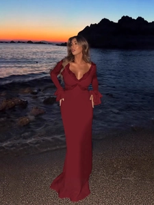 Elegant burgundy V-neck lace maxi dress with bell sleeves on a sunset beach