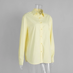 Detailed view of the classic collar and yellow cotton fabric of this long sleeve shirt