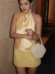 Haut licou en satin jaune élégant avec jupe à paillettes et sac coquillage de vacances