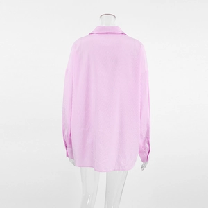 Detail view of pink and white vertical stripes on a loose fit long sleeve cotton shirt