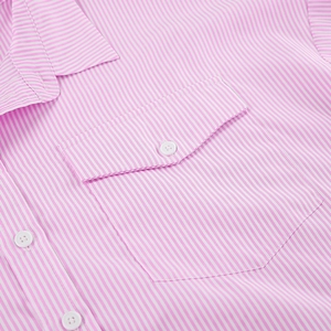 Close-up of pink and white striped shirt with buttoned chest pocket and fine cotton texture