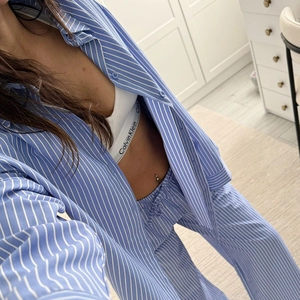Detail view of blue and white striped pajama set with buttons and long pants in soft cotton