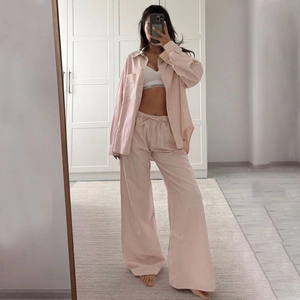 Detail showing pink and white striped pajamas set with long sleeve shirt and loose trousers