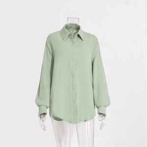 Dettaglio della trama in mussola di cotone verde menta e polsino della camicia