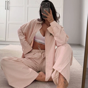 Detail of pink striped pajama set featuring lapel collar and breathable cotton fabric texture