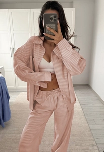 Detail of pink striped loungewear set featuring loose shirt with pocket and drawstring pants