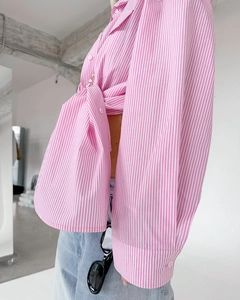 Detailed view of pink striped cotton shirt featuring a stylish knot design at the front hem