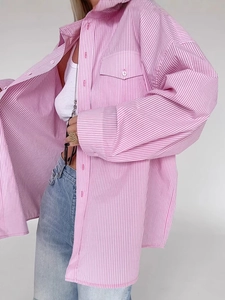 Close-up of pink and white striped oversized shirt with chest pocket and white buttons