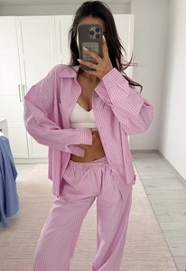 Detail view of pink and white vertical striped pajamas set with button-down shirt and pants