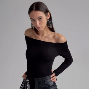 Close-up of slim-fit black off-shoulder long sleeve top with textured fabric and metal belt