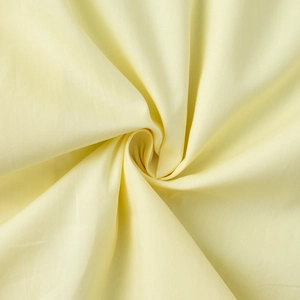 Close-up of light yellow cotton fabric texture showing detailed fine weave and soft material