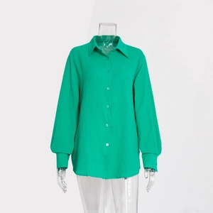 Dettaglio della camicia verde in cotone crepe con texture verticale fine e polsini abbottonati