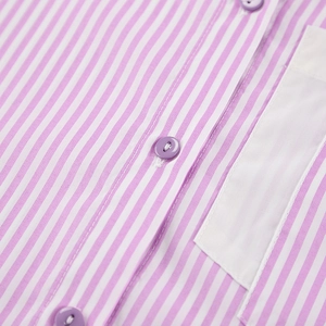 Detail of pink and white striped shirt showing purple buttons and neat stitching