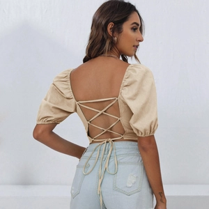 Detailed back view of a beige crop top with open back design and cross lace-up ties