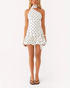Detail of white polka dot halter mini dress with ruffled hem and waist tie ribbon