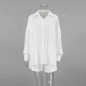 Detail of white cotton jacquard fabric with pleated texture on lantern sleeve shirt and shorts