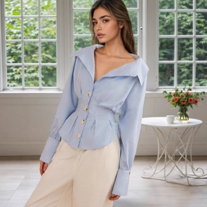 Detail of elegant blue striped shirt showing structured lapel and pleated waist design