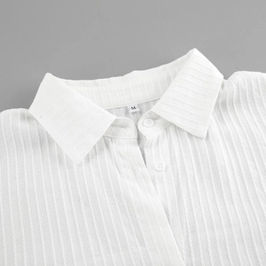 Close-up of white cotton jacquard shirt collar with buttons and size M tag detail
