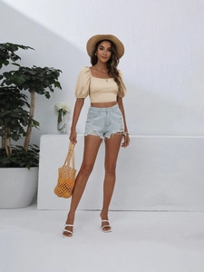 Women's beige square neck puff sleeve crop top with light blue distressed denim shorts