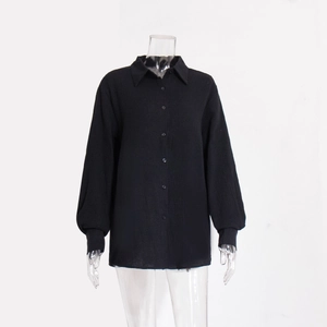 Dettaglio della camicia nera in cotone crepe con colletto a polo e trama del tessuto