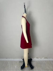 Détail d'une robe dos nu bordeaux avec boutons dorés et ourlet de jupe trapèze