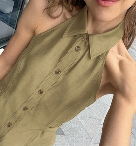 Detailed close-up of the olive green halter collar and fabric texture of the sleeveless top