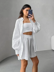 Detail view of white three-piece cotton set with textured jacquard and lantern sleeves