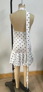 Rear view of white polka dot halter dress with open back and tiered ruffle hem on a mannequin
