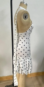 Detail of white polka dot dress showing halter neck design and ruffled hemline textures