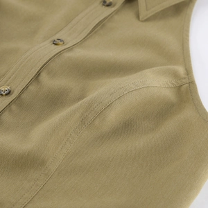 Detail of olive sleeveless top featuring marble buttons and premium twill fabric texture