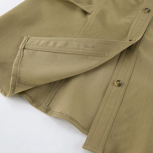 Detail of khaki cotton twill fabric with amber textured buttons and neat hem stitching