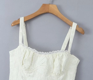Gros plan sur la robe blanche à épaules dénudées avec tissu jacquard fleuri et dentelle