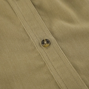 Macro shot of khaki twill fabric texture and marble resin button on a women's halter top