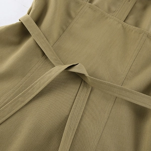 Detailed close-up of the waist belt and premium fabric texture of the olive green top