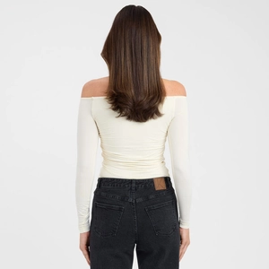 Detail of off-shoulder slim fit cream long sleeve top with textured stretch fabric