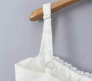 Détail de robe blanche en tissu jacquard floral avec bordure en dentelle sur l'encolure