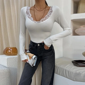 Close-up of white rib-knit long sleeve top featuring delicate floral lace V-neckline