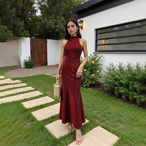 Gros plan d'une robe de soirée à paillettes rouge foncé avec décolleté licou et fente