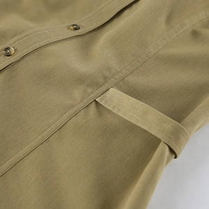 Close-up of khaki halter top fabric texture featuring resin buttons and double stitching