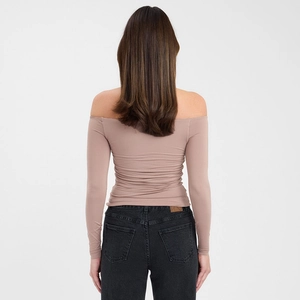Rear view of tight-fitting off-shoulder long sleeve top in earthy brown fabric