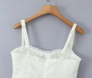 Détails des bretelles réglables et de la dentelle sur une robe blanche pailletée évasée