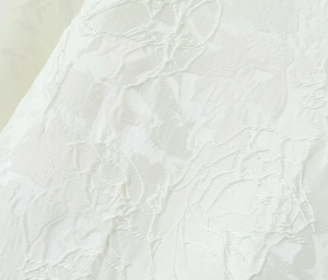Détail du tissu jacquard blanc avec motif floral élégant et finition aspect soie