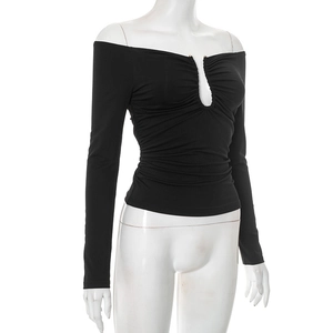 Detailed view of ruched off-shoulder neckline and sexy V-neck cutout on black long sleeve top