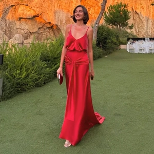 Detail of red silk evening gown showing lustrous satin fabric and waist ribbon detail