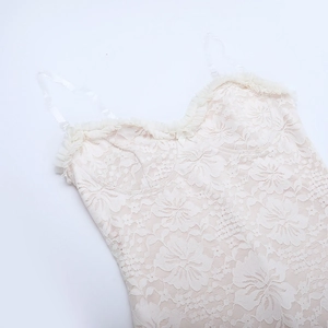 Detailansicht der floralen Spitze und des gerüschten Ausschnitts dieses cremeweißen Tops