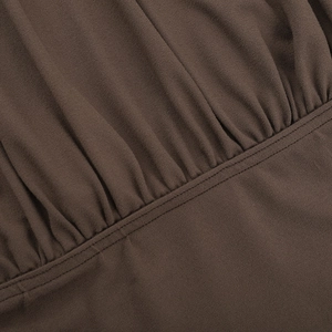Detailed macro view of pleated brown knit fabric texture with neat double-needle stitching