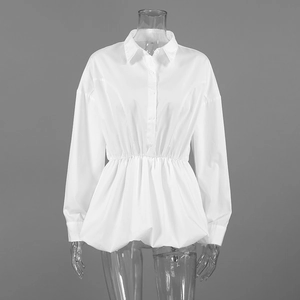 Detailed close-up of white cotton shirt showing lapel collar and waist cinching detail