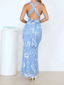 Detail of cross-back halter dress featuring 3D floral embroidery and a tie-up bow