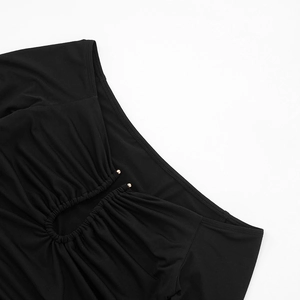 Detail of black off-shoulder top featuring ruching and teardrop cutout with gold beads