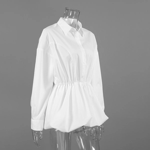 Detail view of white cotton shirt featuring elastic pleated waist and peplum hem design